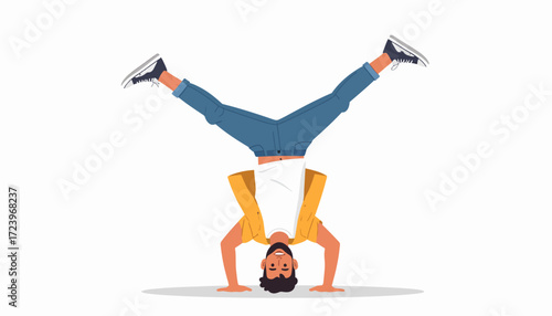 A man is performing a handstand with his legs spread apart, wearing jeans and a yellow shirt.