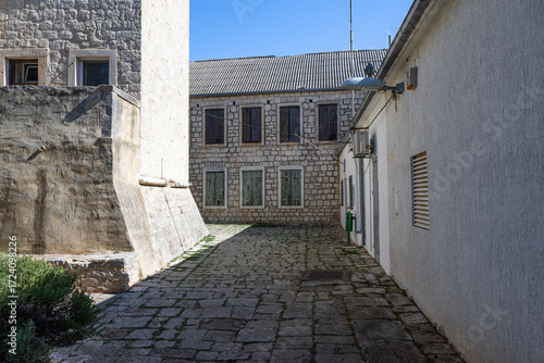 Historic Stone Building With Tower and Flag Over Courtyard in Sunny European Town, Grohote, Solta