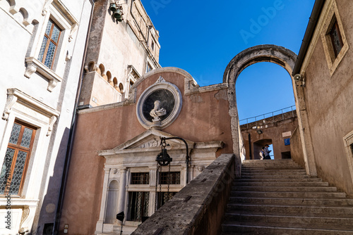 Historic arch and stairs leading up to Castel Sant'Angelo in Rome on a sunny day. Renaissance architecture and clear blue sky.