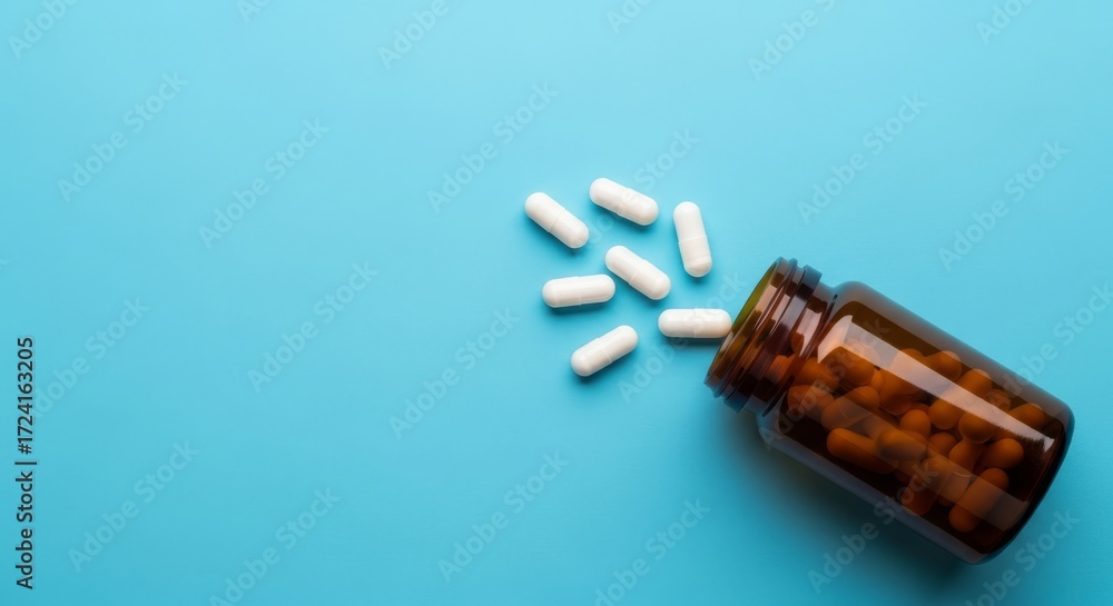 Naklejka premium Boost your health with vitamins and supplements spilling from a bottle, promoting wellness and a balanced lifestyle on a calming blue background