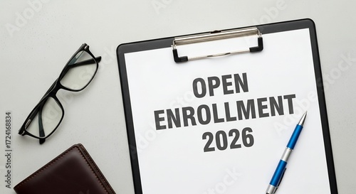 Open enrollment 2026 document on clipboard with glasses and pen