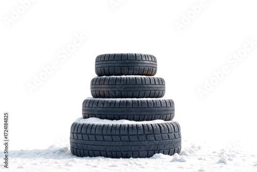 Stack of four winter tires sitting on snow in bright white background