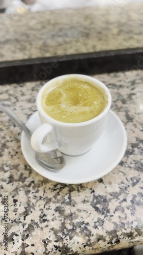 Steaming cup of coffee on a table in a cozy café setting, symbolizing morning routine, relaxation, caffeine boost, and European coffee culture.