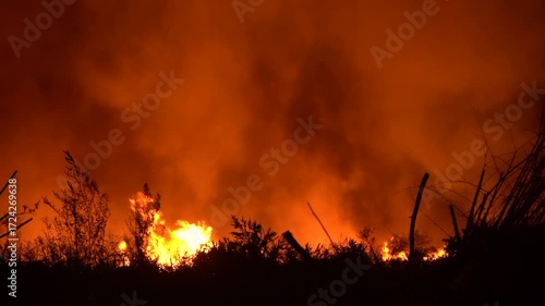 Fire at the garbage dump, night footage of a raging fire at the dump. Garbage burns and thick smoke rises, the fire spreads and flares up