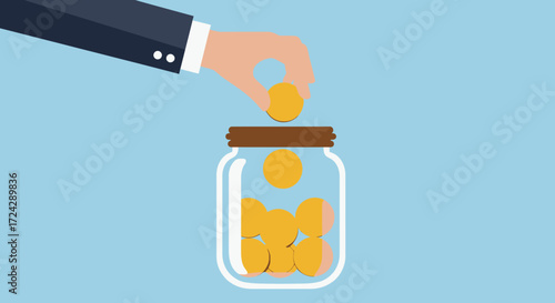 A person's hand is carefully placing a shiny gold coin into a clear glass jar, symbolizing financial savings and future investment.