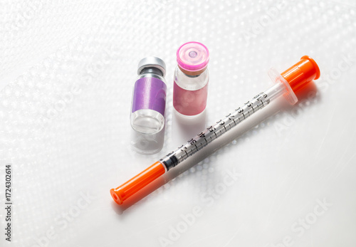 Close up of Vial with Injectable Compounds Next to Syringe