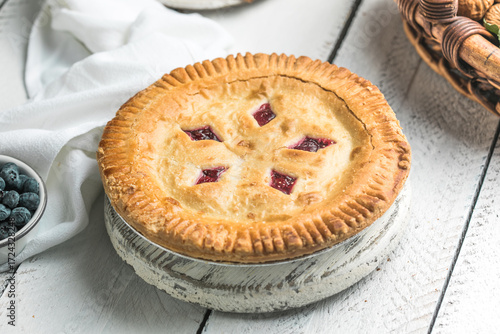 Cherry and blueberry pie on white wooden boards, homemade rustic dessert