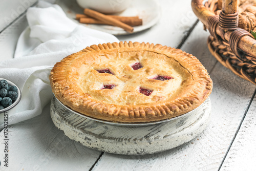 Cherry and blueberry pie on white wooden boards, homemade rustic dessert