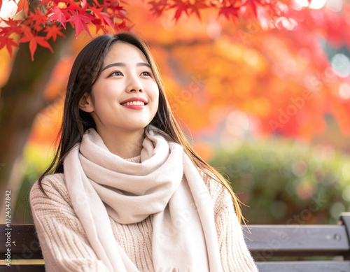 公園で紅葉を楽しむ若い女性/Young woman enjoying autumn leaves in the park