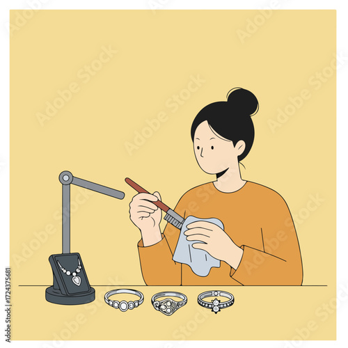 Woman polishing jewelry with brush and cloth. Rings & necklace stand displayed