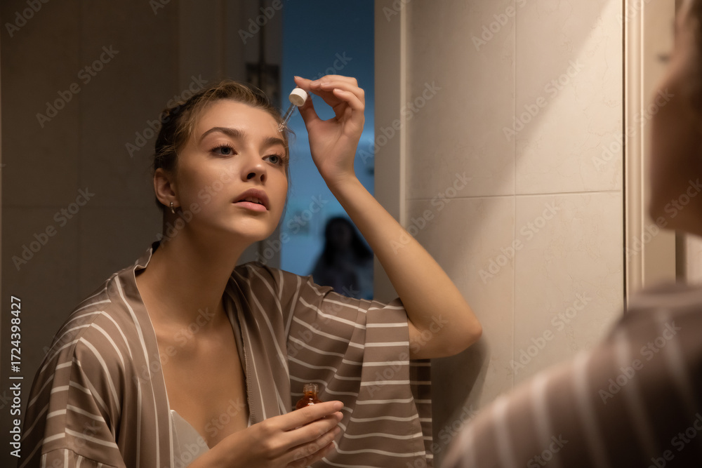 custom made wallpaper toronto digitalBeautiful young woman taking care of her face at home, skincare procedures, selective focus. Portrait of a woman applying a serum and doing face massage for her face in her bathroom. Real photo.