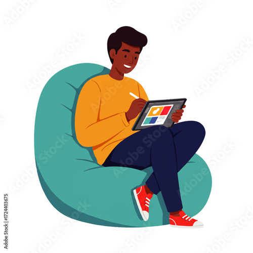 An African American man sits in a beanbag chair, using a stylus on a tablet device.