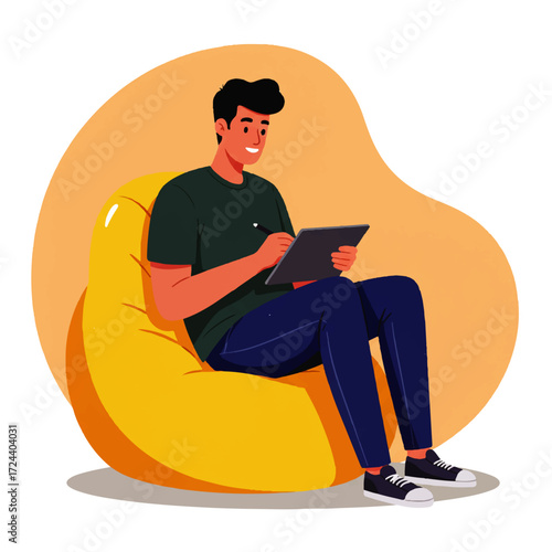 A young man sits comfortably in a yellow beanbag chair, smiling as he draws or works on a tablet with a stylus.