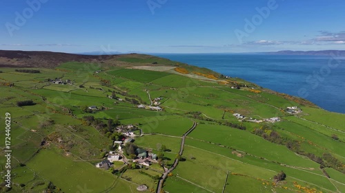 Drone view of the Farms and homes on the Beautiful Rolling hills of the coast of Ireland on the Irish Sea