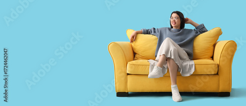 Young woman sitting on yell...