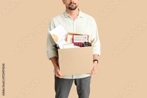 Fired young man holding box...