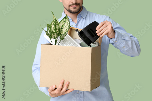Fired young man packing his...