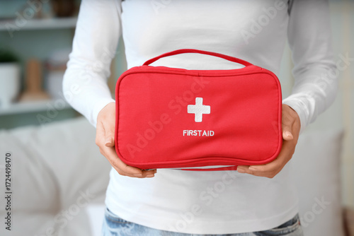 Woman holding first aid kit...