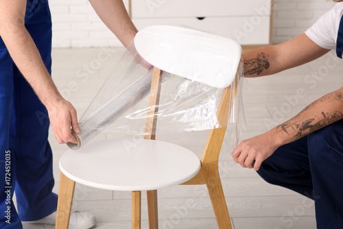 Male loaders wrapping chair...