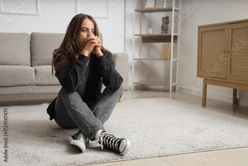 Sad young woman sitting on ...