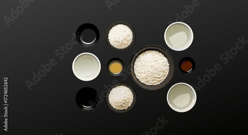 Culinary Palette: An overhead view of culinary ingredients, featuring bowls of rice and sauces, artfully arranged on a sleek, dark surface, inviting food lovers.