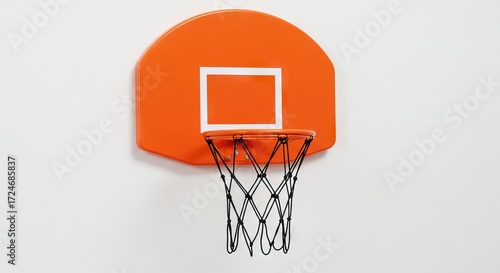 An orange mini basketball hoop with a black net is mounted on a white wall