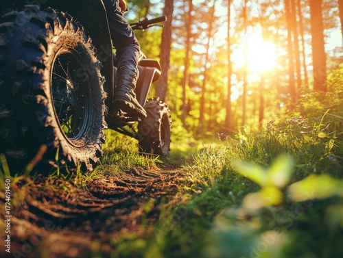 Person riding motorcycle on forest trail with close-up of atv wheel tracks in the dirt