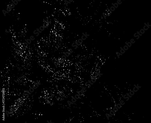 Raindrops shining on a dark surface, creating a sparkling abstract texture