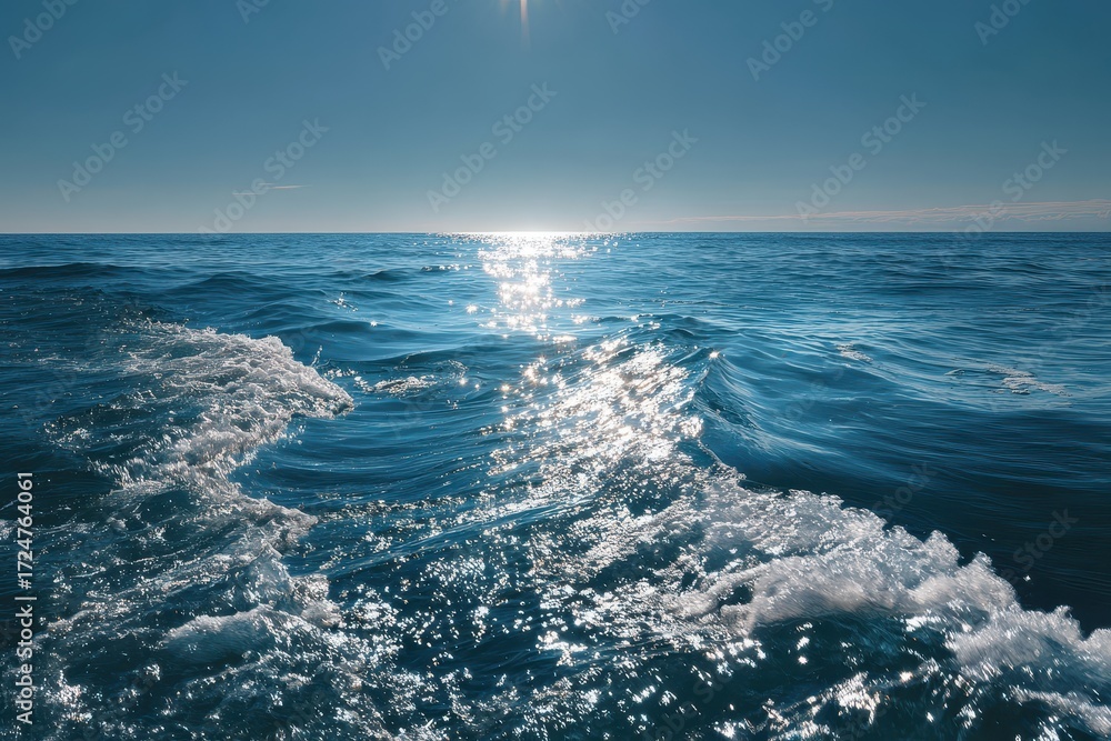 Obraz premium Serene ocean waves gently roll on deep blue water under the bright sun, creating a tranquil atmosphere perfect for relaxation and reflection near the horizon