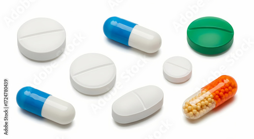 A collection of assorted pharmaceutical pills and capsules, including round white tablets, blue and white capsules, and an orange and yellow capsule, arrange...
