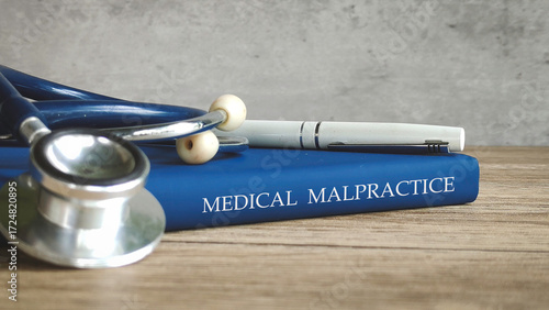 Obraz na płótnie Stethoscope and a pen on a book titled MEDICAL MALPRACTICE, representing legal issues in healthcare