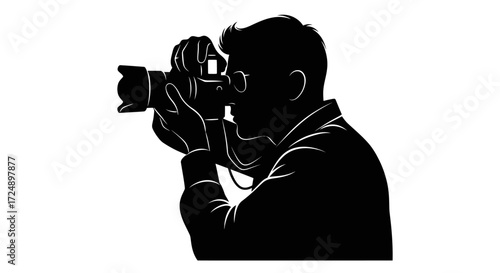 Artistic Silhouette of a Professional Man Photographer Intently Composing a Camera Picture