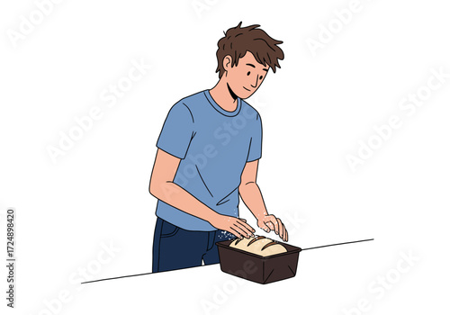 A young man carefully places freshly baked bread in a loaf pan.