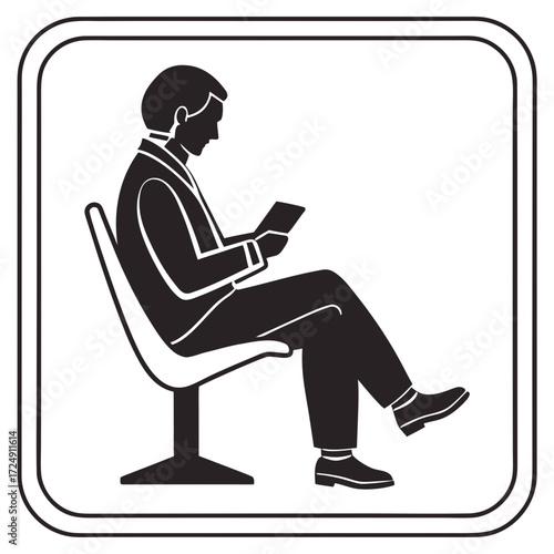 Silhouette of a businessman sitting on a modern chair and reading a tablet device in a waiting area or office lobby