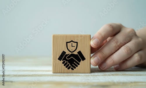 Handshake and shield symbol on wooden block represents security and trust