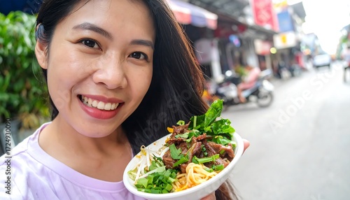 Smiling woman enjoys delicious Asian noodle dish outdoors