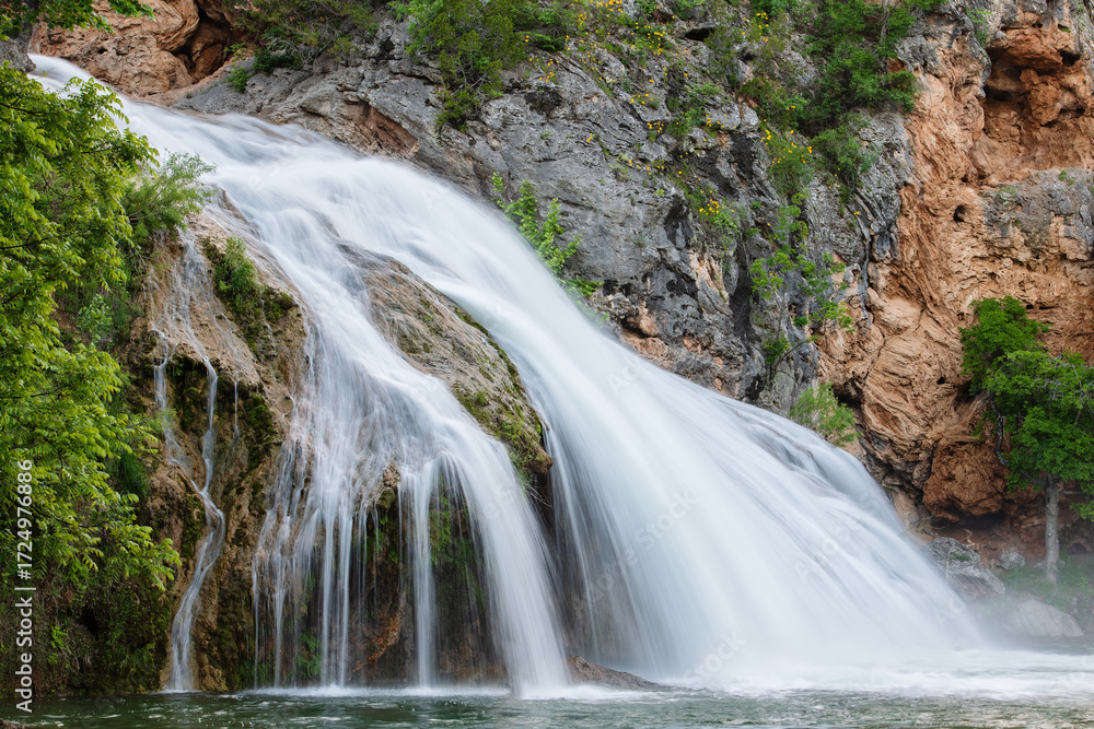 Obraz premium Beautiful cascade waterfall captured with a long exposure with natural pool water. Scenic landscape, ideal for backgrounds and travel concepts. Turner Falls Park, Oklahoma