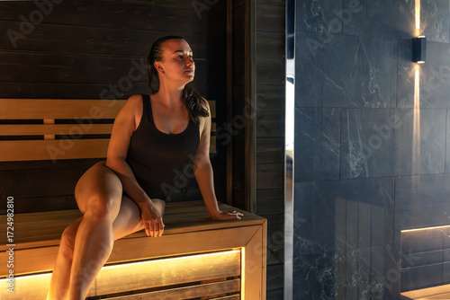 Φωτογραφία Woman on sauna bench, looking to light, spa lifestyle