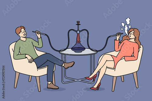 Man and woman smoke turkish hookah, sitting at table in bar and enjoying taste of tobacco. Dating of happy couple with hookah, for opportunity to chat and relax in comfortable atmosphere