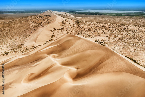 Aerial view of singing sand dune rising in the desert landscape of Altyn Emel National Park in Kazakhstan