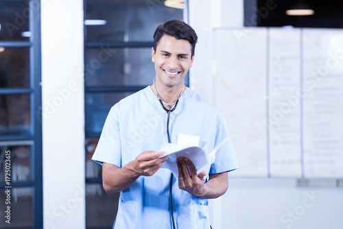 Stethoscope resting on patient charts leaning on whiteboard with glass partitions revealing desk