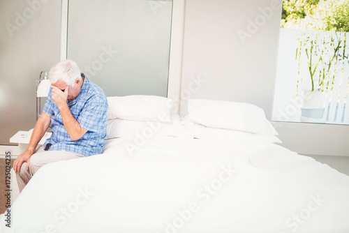 White bedding resting on bed by nightstand and mirrored closet door with window showing greenery