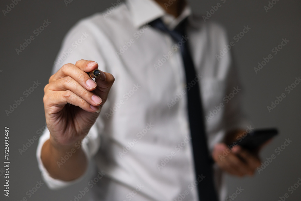 Fototapeta premium man in white shirt and black tie is holding cell phone and pen