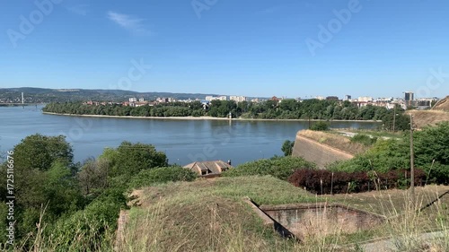 A city surrounded by greenery and water, observed from the top of a fortress.