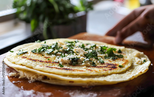 Freshly prepared tortillas filled with cheese and herbs being served in a vibrant kitchen during a sunny afternoon