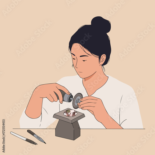 A jeweler carefully works on a gem with a grinder