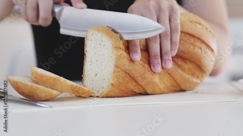 A young woman prepares fresh sandwiches with butter, sausage, and cheese on crispy bread. Close-up shots showcase the appetizing food preparation process in a modern kitchen