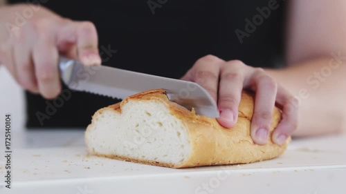 A woman prepares delicious sandwiches with cheese, butter, and sausage in a sunny kitchen. Authentic cooking process showcasing simple, comforting food preparation