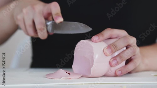 A woman prepares delicious sandwiches with cheese, butter, and sausage in a sunny kitchen. Authentic cooking process showcasing simple, comforting food preparation