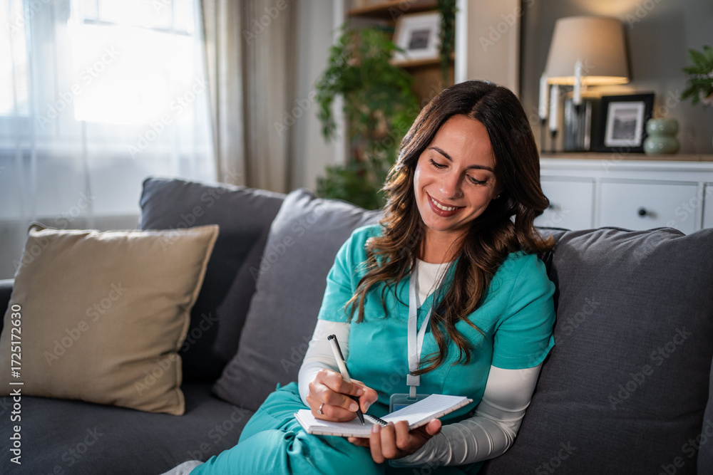 Εκτύπωση καμβά Smiling nurse writing notes during a home visit